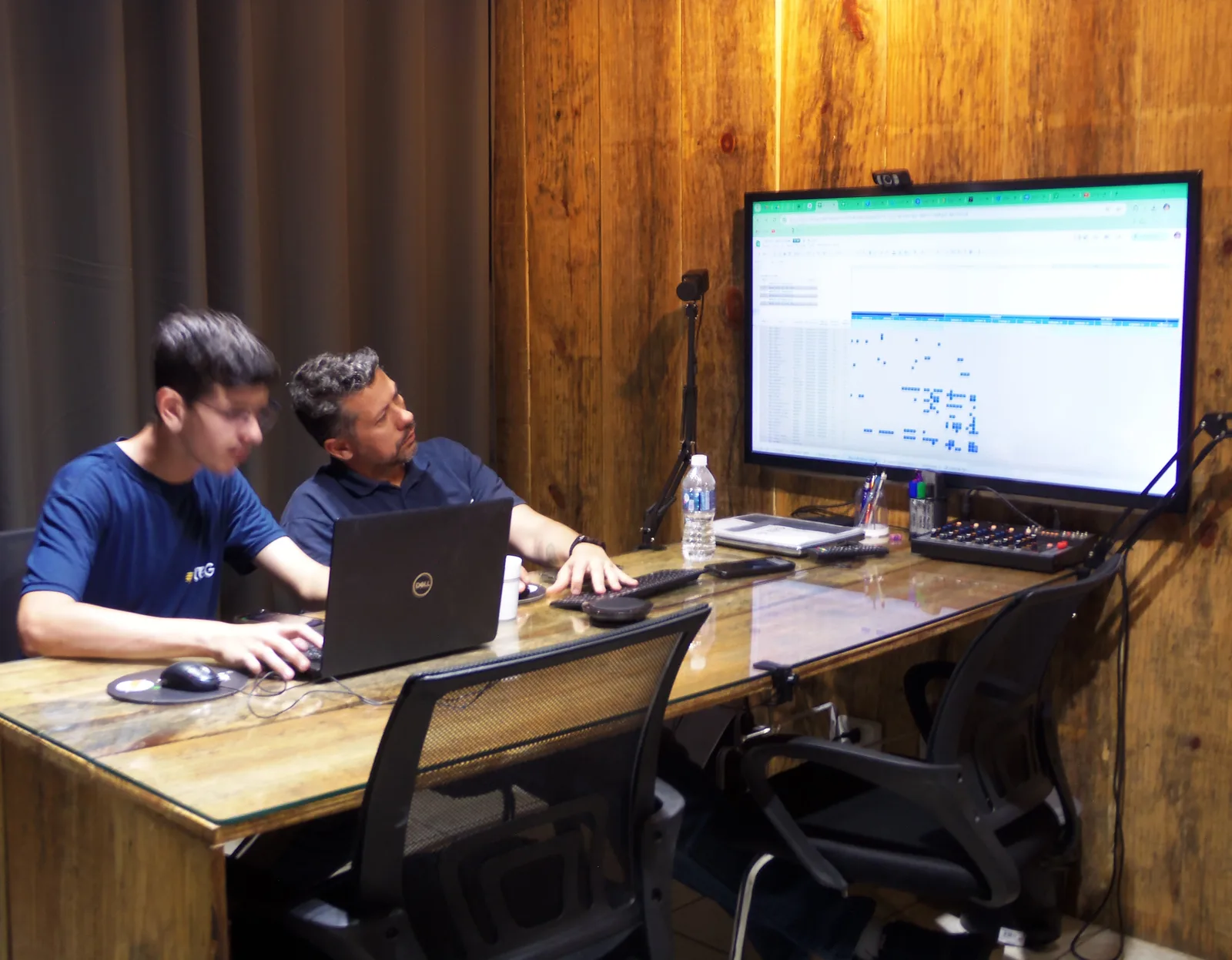 Dois técnicos da TEG em uma mesa de trabalho, acompanhando dados de monitoramento em um monitor